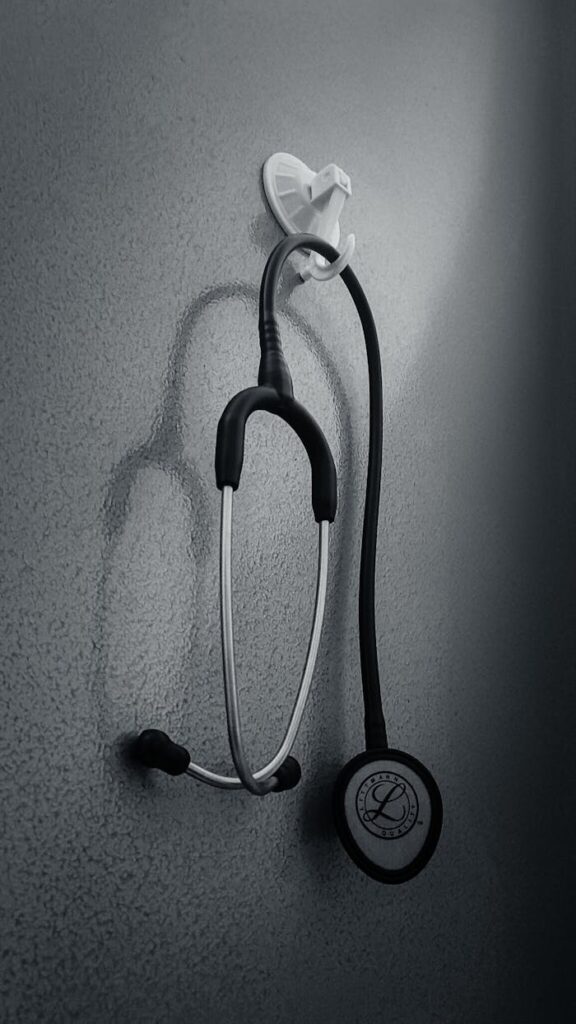 Monochrome image of a stethoscope hanging on a wall, conveying a medical theme.